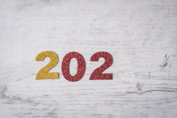 灰色的木制背景上闪烁着金黄色和红色的毛毡号码 202 的组合 — 图库照片