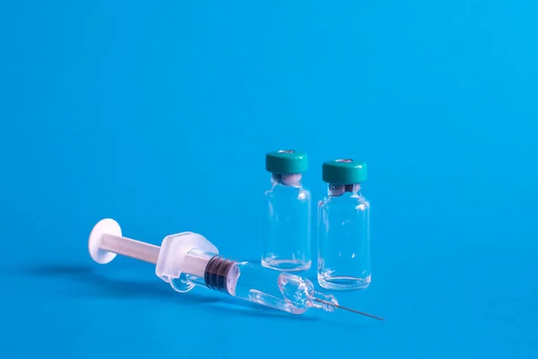 Een Close Van Een Injectienaald Met Vaccinampullen Tegen Een Blauwe — Stockfoto