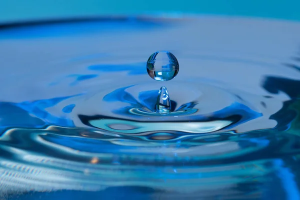 Una Toma Increíble Una Gotita Rebotando Agua Fondo Azul —  Fotos de Stock