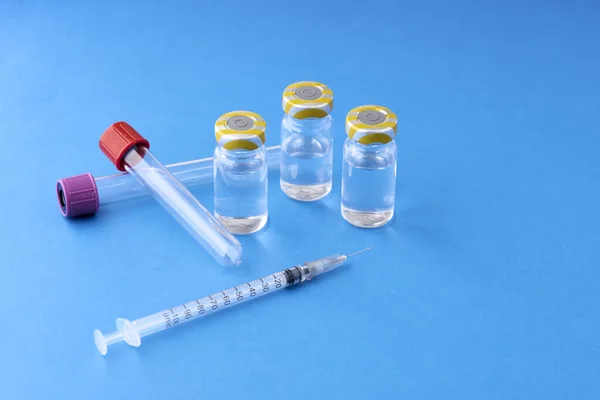 Vysokoúhlý Záběr Injekční Jehly Vakcinačními Ampulkami Modrém Povrchu Covid — Stock fotografie