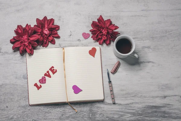 Słowo Miłość Otwartej Stronie Notatnika Długopis Kwiaty Filiżanka Kawy Szarej — Zdjęcie stockowe