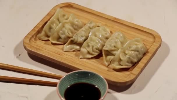 Træ Skærebræt Med Kinesiske Dumplings Spisepinde Sojasovs Skål Top View – Stock-video