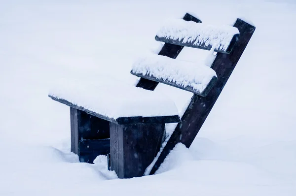 一张站在街上的雪地上的木制长椅的特写照片 — 图库照片