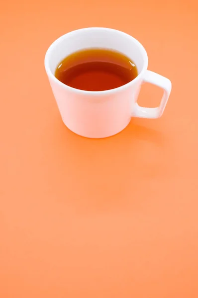 Eine Vertikale Aufnahme Einer Tasse Tee Auf Einer Orangefarbenen Oberfläche — Stockfoto