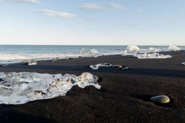 Крупный План Гладких Камней Ледяных Образований Разбросанных Пляжу Черного Песка — стоковое фото