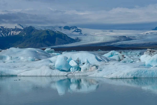 アイスランドの山に囲まれた海に反射する氷山のラグーンと美しい風景 — ストック写真