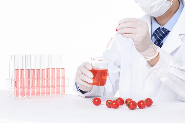 研究室でチェリートマトに毒性物質を追加する科学者の閉鎖 — ストック写真