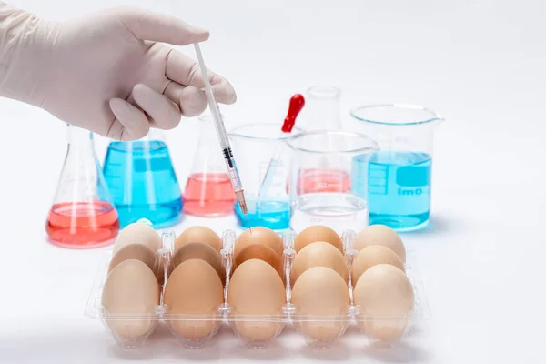 A closeup of a scientist injecting toxic substances into an egg in a laboratory