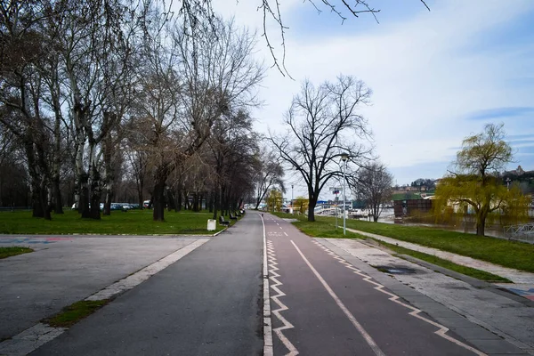 Piękne Ujęcie Ulicy Pomiędzy Parkiem Rzeką Nagimi Drzewami Okresie Wiosny — Zdjęcie stockowe