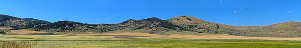 Een Panoramisch Shot Van Bergen Landbouwvelden Onder Blauwe Hemel — Stockfoto