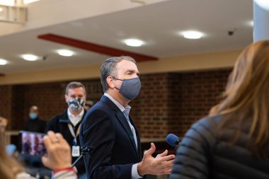 ALEXANDRIA, UNITED STATES - Jan 13, 2021: Alexandria, Virginia/USA- January 12th, 2020: Virginia Governor Ralph Northam speaking to reporters at a Covid vaccination site. clipart