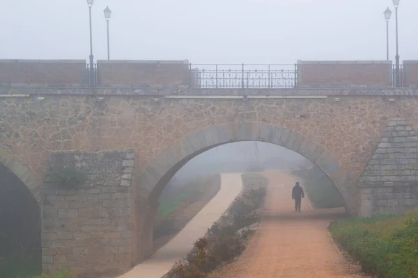 Силуэт Человека Идущего Мостом Красноватой Дорожке — стоковое фото