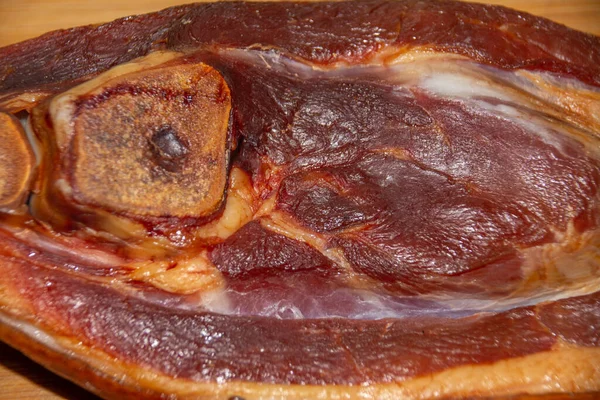 Sebuah Tembakan Dekat Dari Sepotong Kaki Babi Asap Permukaan Kayu — Stok Foto