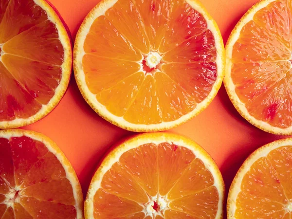 A top view of Blood orange round slices on orange background