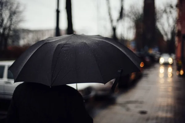 Hombre Con Paraguas Negro Caminando Por Calle Con Fondo Borroso — Foto de Stock
