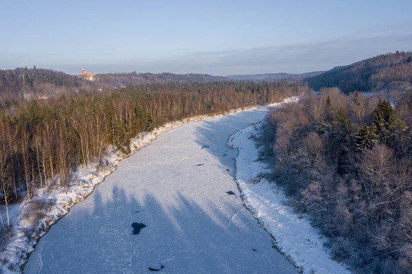 冬の日に雪に覆われた森の中を流れる川で氷を溶かす空中ショット — ストック写真