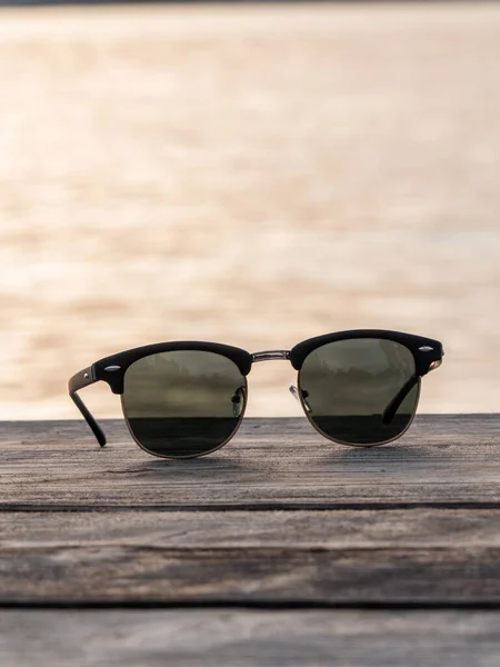 Eine Vertikale Nahaufnahme Einer Sonnenbrille Auf Einem Holzboden — Stockfoto