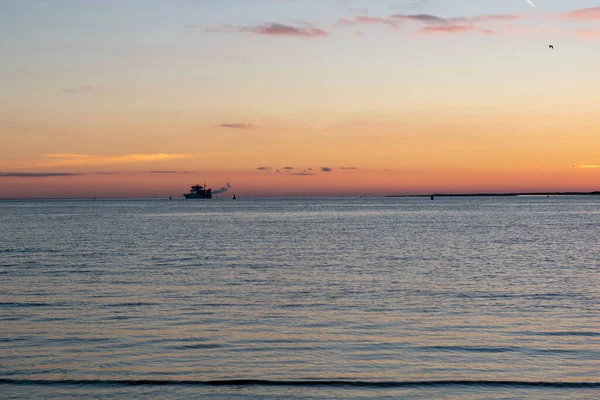 ドイツ ノルデルニーの夕暮れ時に水平線に帆船と穏やかな海の景色 — ストック写真