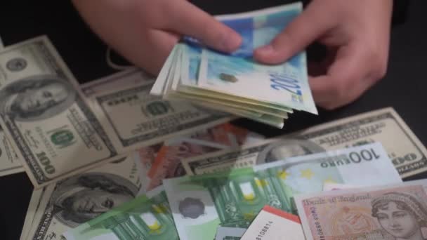 男孩用不同的外币数着桌上的以色列谢克尔钞票 — 图库视频影像