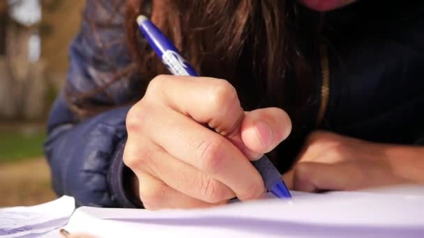 Una Chica Sosteniendo Pluma Azul Escribiendo Algo Pedazo Papel Blanco — Vídeos de Stock