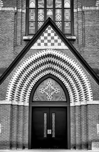 天主教教堂入口的垂直灰度照片 — 图库照片