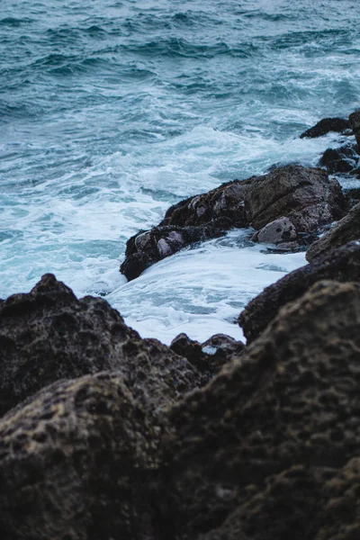 在海岸的岩石上 一道垂直的海浪拍击着 — 图库照片