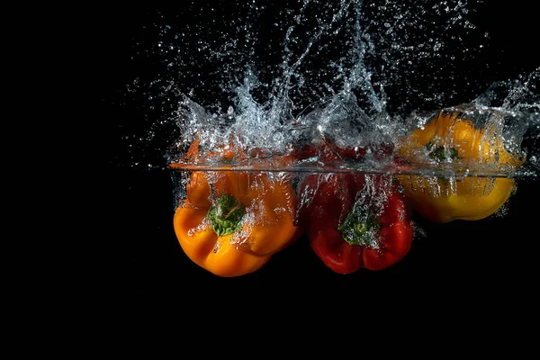 Una Vista Ravvicinata Peperoni Colorati Caduti Acqua Creando Una Spruzzata — Foto Stock