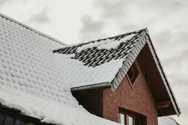 Niski Kąt Strzał Dachu Ceglanego Budynku Nakrywanego Śniegu Pod Zachmurzonym — Zdjęcie stockowe