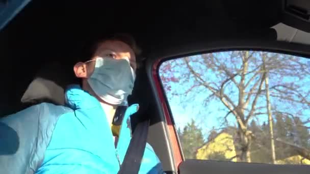 驾驶汽车时戴外科面罩的年轻人的低视角视野 大肠病毒 大流行病预防 — 图库视频影像