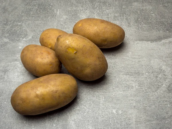 Gruppe Von Fünf Rohen Ungekochten Braunen Kartoffeln Auf Grauem Hintergrund — Stockfoto
