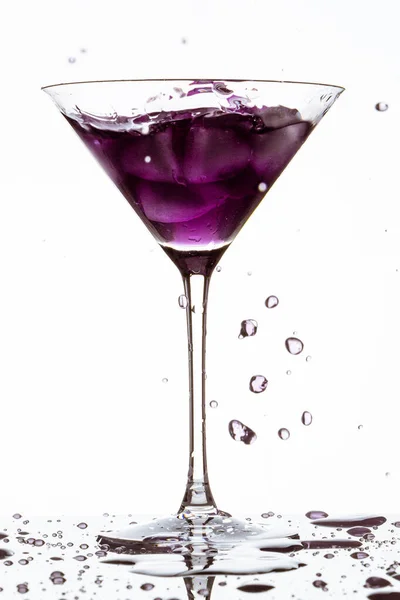 白い背景に飛び出る紫色のカクテルのガラスの垂直閉鎖 — ストック写真
