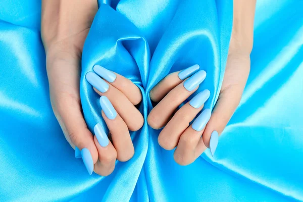 Closeup Shot Female Hands Blue Nail Polish Blue Silk Fabric — Stock Photo, Image