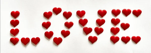Het Woord Liefde Geschreven Met Kleine Rode Hartvormen Tegen Een — Stockfoto