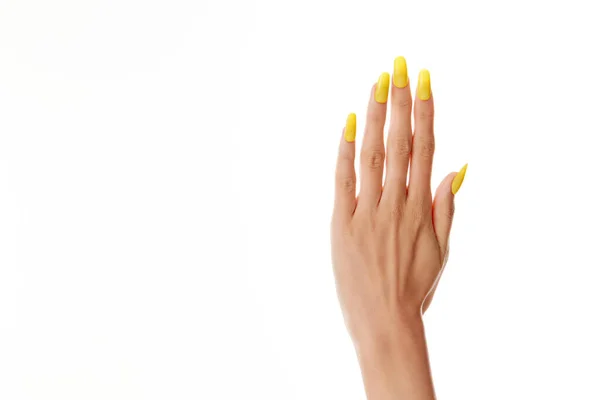 Close Mão Uma Mulher Com Esmalte Amarelo Fundo Branco — Fotografia de Stock