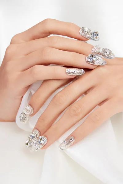 爪の上にダイヤモンドを持つ女性の手の垂直ショット — ストック写真