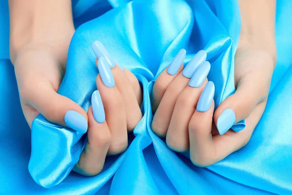 Closeup Shot Female Hands Blue Nail Polish Blue Silk Fabric — Stock Photo, Image