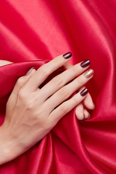 Ένα Κάθετο Πλάνο Γυναικείων Χεριών Βερνίκι Νυχιών Κόκκινο Μεταξωτό Ύφασμα — Φωτογραφία Αρχείου