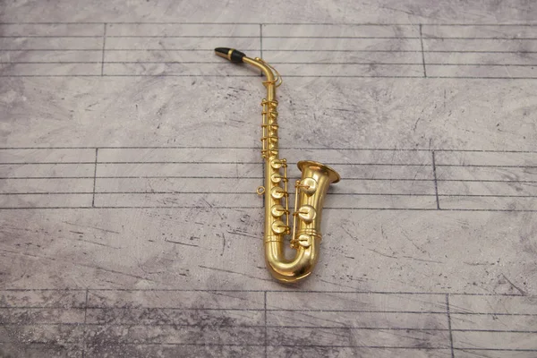 Music Sheet Background Miniature Saxophone — Zdjęcie stockowe