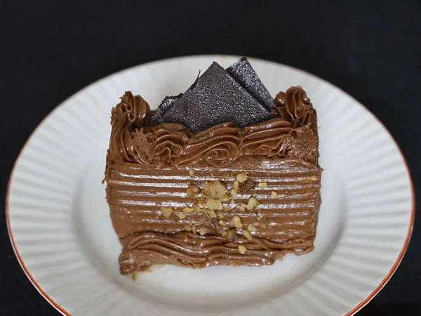 Кусок Шоколадного Торта Карамельной Начинкой Украшенный Орехами Тарелке — стоковое фото