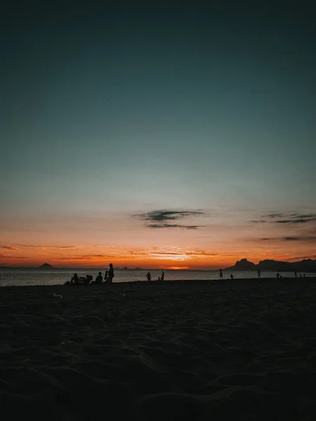 Вертикальный Снимок Заката Песчаном Пляже Людей Наслаждающихся Вечером — стоковое фото