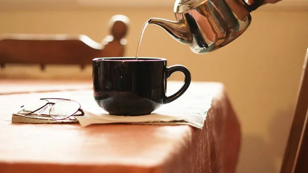 Zbliżenie Ujęcie Czarnego Ceramicznego Kubka Polewająca Herbata Czajnika — Zdjęcie stockowe