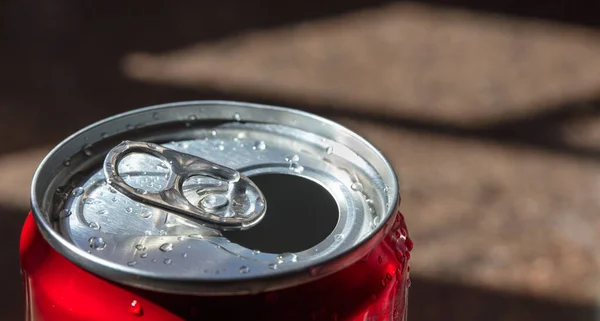 A closeup of open soda can with water dropson blurred background