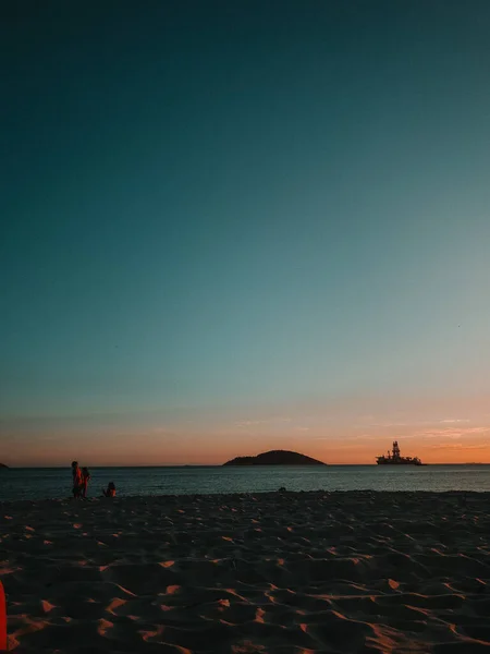 Μια Κάθετη Λήψη Του Ηλιοβασιλέματος Στην Αμμώδη Παραλία Και Άνθρωποι — Φωτογραφία Αρχείου