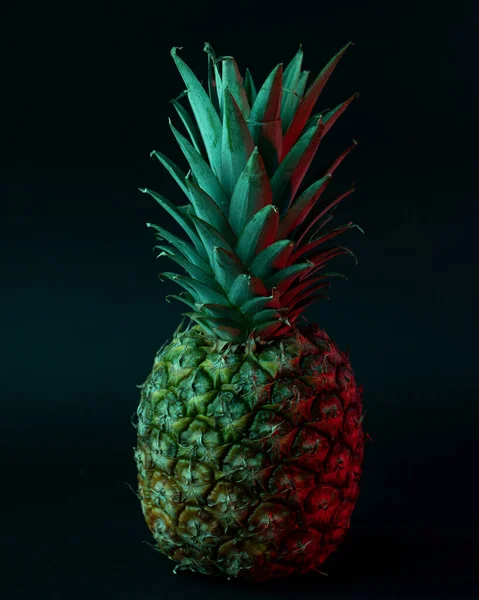 Vertikální Záběr Ripe Ananas Zeleným Osvětlením Černém Pozadí — Stock fotografie