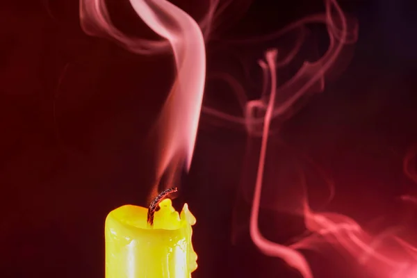 一支熄灭的黄色蜡烛的特写镜头 在栗色背景上冒着烟 很适合背景墙纸 — 图库照片
