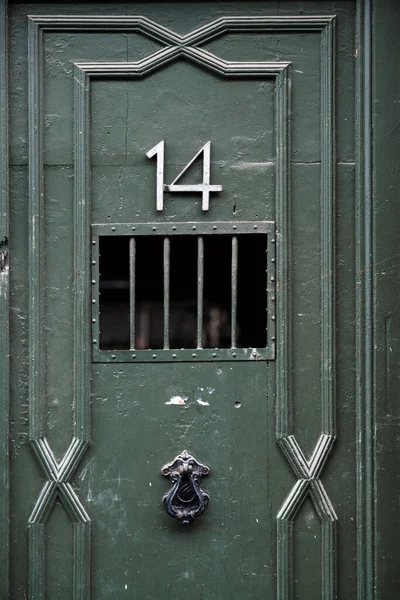 パターン ノッカーが付いた古い緑のドアの垂直ショット — ストック写真