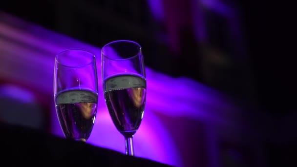 Hdでお祝いパーティー中にバブルシャンパンと2つのエレガントなグラスの閉鎖 — ストック動画
