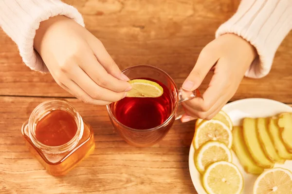 蜂蜜と生姜と熱いお茶のカップにレモンスライスを入れて女性 ホームトリートメント — ストック写真