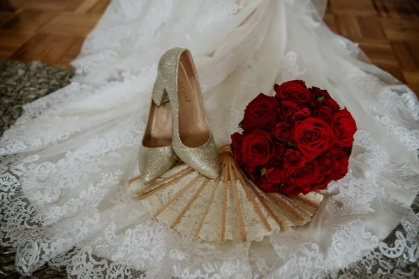 Een Bruidsboeket Met Rode Rozen Bij Schoenen Bruidsjurk — Stockfoto