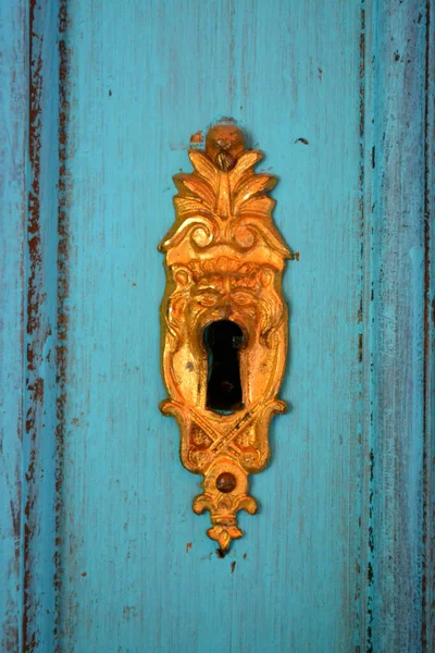 トルコ石の木製の背景に金色の鍵穴の垂直ショット — ストック写真